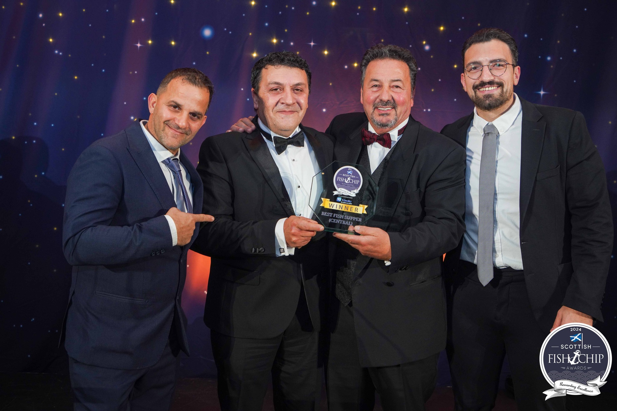 A proud awards-night group photograph